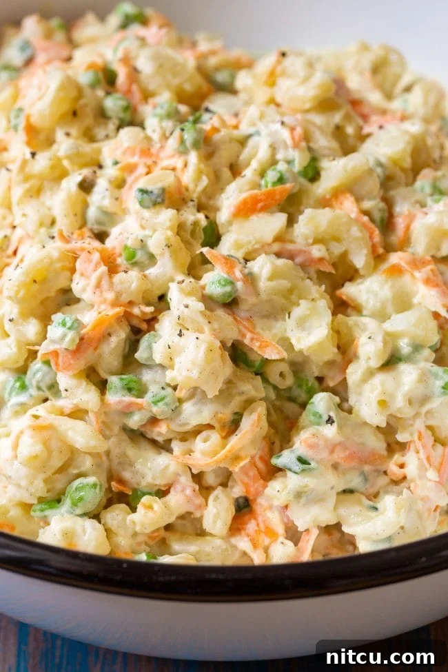 Macaroni salad in a large serving bowl, garnished and ready for serving.