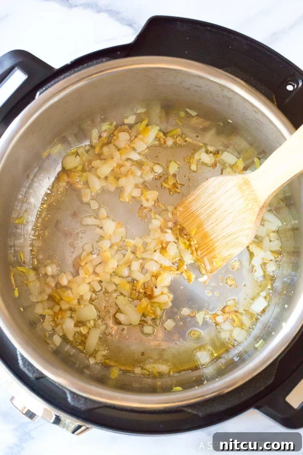 Sauteeing diced onions in an Instant Pot to build a flavorful base.