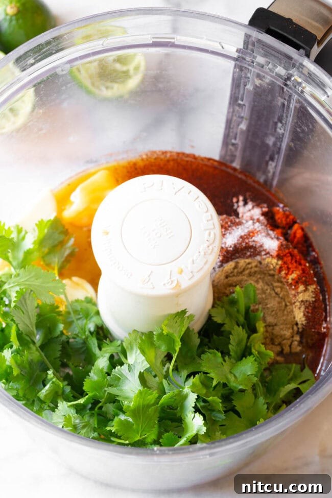 Ancho chili powder and other spices being blended in a food processor for the Carne Asada marinade.