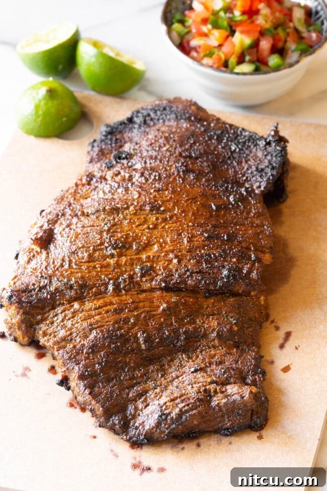 Sizzling Carne Asada steak cooking in a hot cast iron skillet, showcasing a perfect sear.