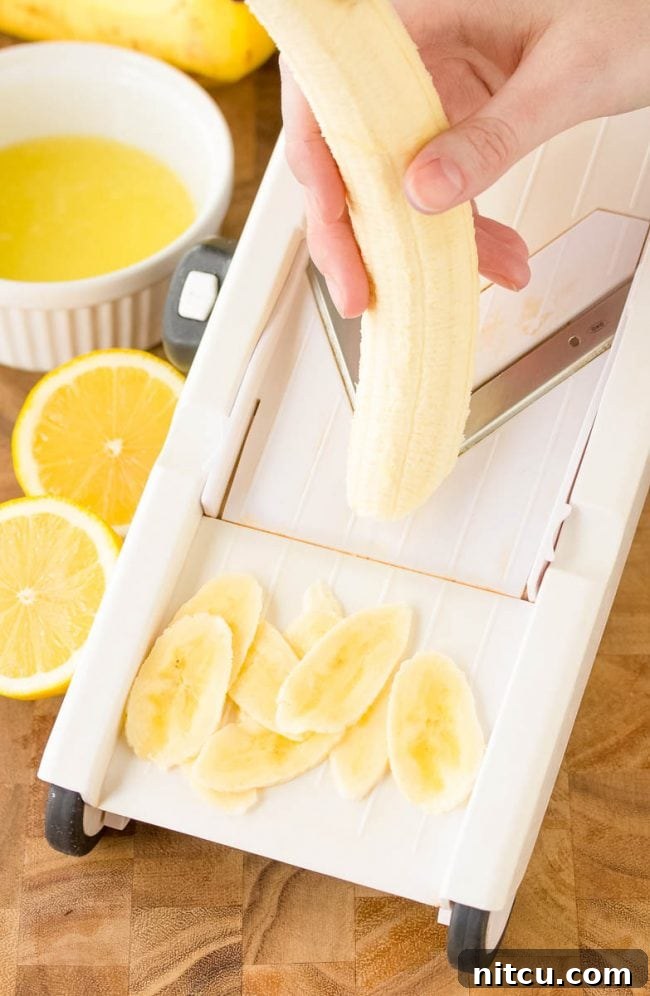 Using a mandolin slicer to cut up the bananas