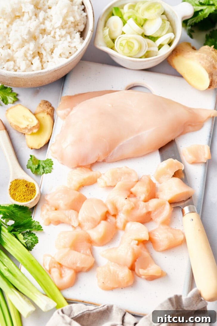 Chopping chicken breast into bite-sized pieces, a crucial first step for this Classic Thai Fried Rice Recipe.
