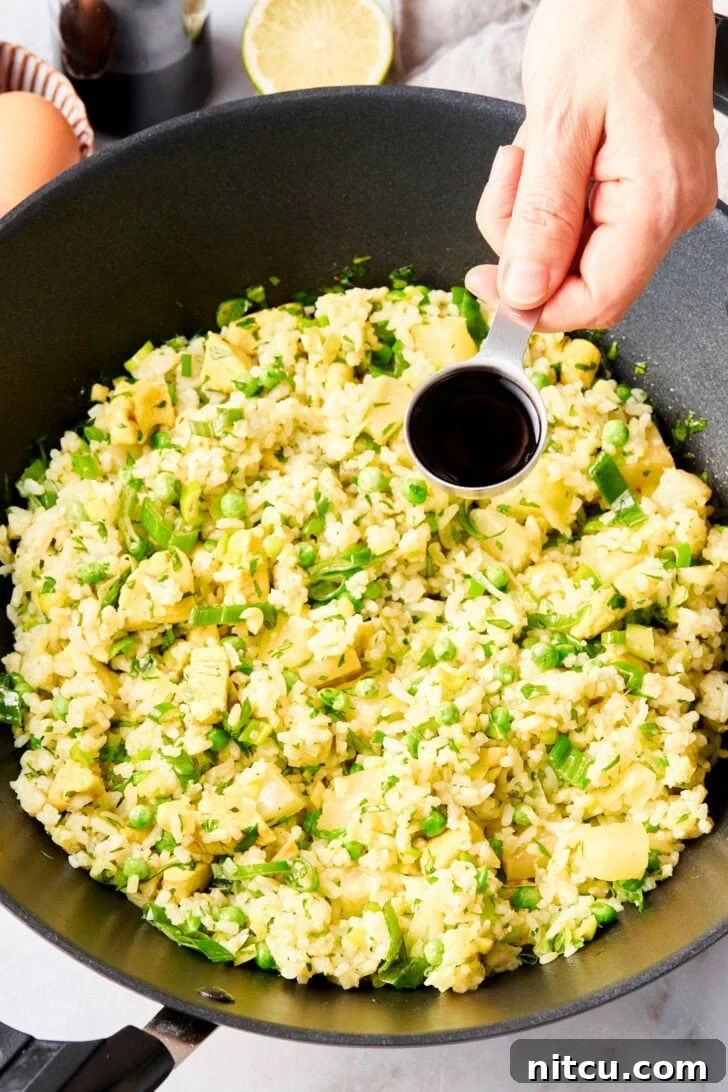 All the delicious ingredients for Thai fried rice tossed together in a large skillet, nearing completion.