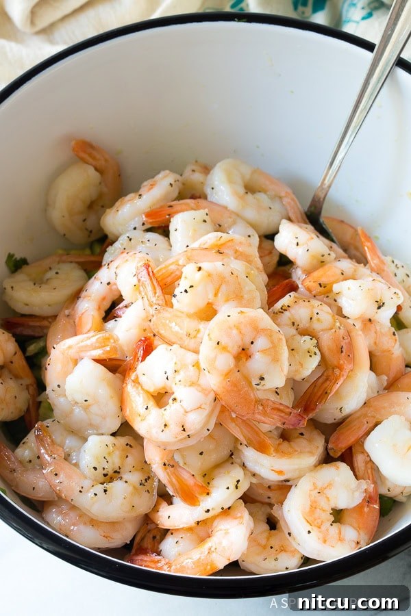 Assembling the vibrant Garlic Lime Roasted Shrimp Salad with herbs and avocado
