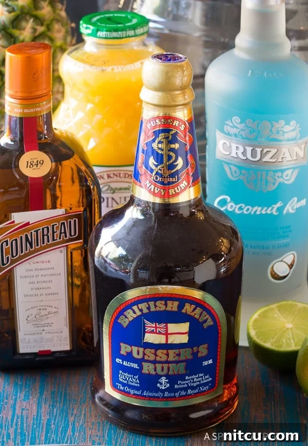 Preparing large-batch Goombay Smash Caribbean cocktails, showing the mixing process in a big pitcher or dispenser