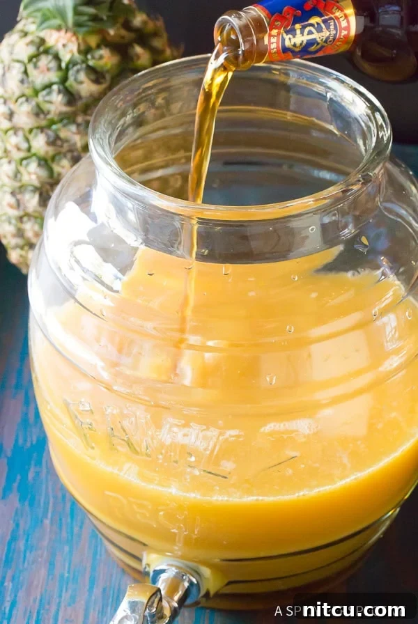 Goombay Smash ingredients, including various rums, pineapple juice, and lime juice, mixed in a large jug