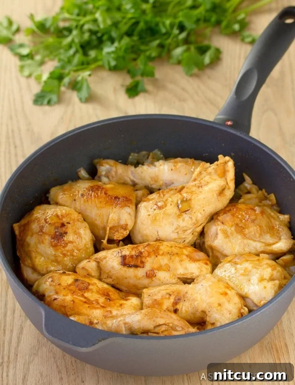 Browned chicken pieces in a skillet, ready for the Paprikash sauce