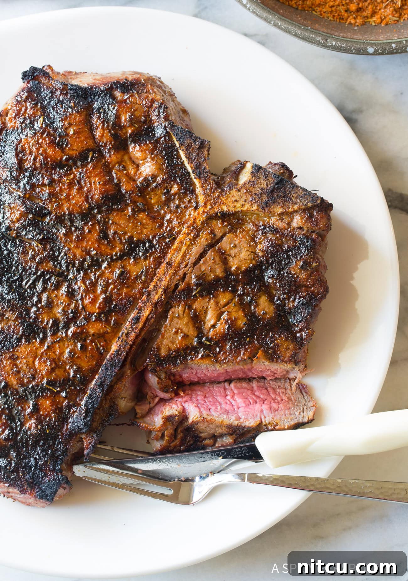 A medium-rare steak, sliced open to reveal its perfectly pink interior, rests on a plate, showcasing ideal doneness.