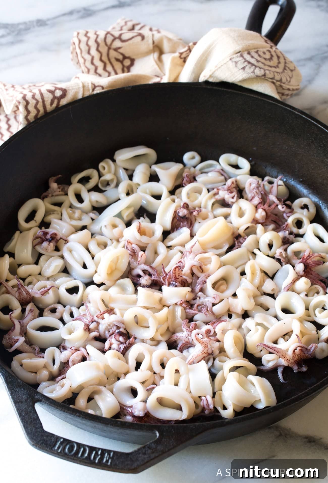 Octopus and squid in a cast iron skillet.