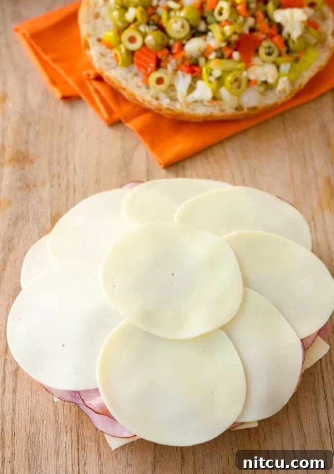 The top half of the Italian bread loaf, lightly hollowed out, ready to be placed over the overflowing olive salad and fillings.