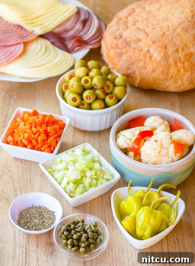 A beautiful flat lay of all the fresh ingredients needed to make a New Orleans Muffuletta Sandwich, arranged artfully on a wooden background.