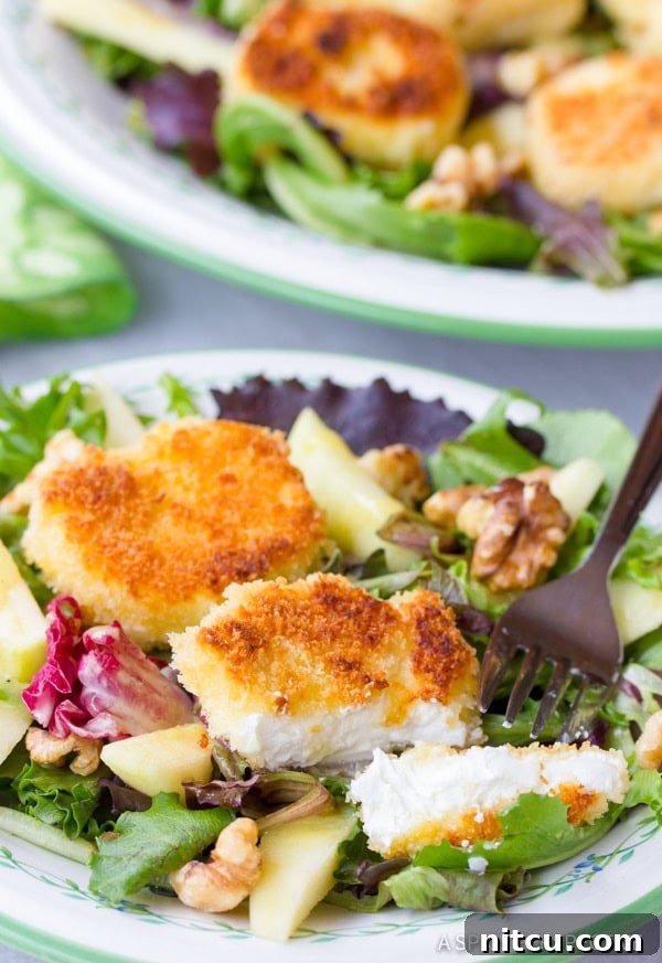Close-up of a single serving of Fried Goat Cheese Salad on a plate with a fork.