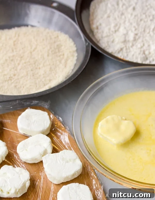 Rounds of goat cheese being dredged in batter and breadcrumbs.