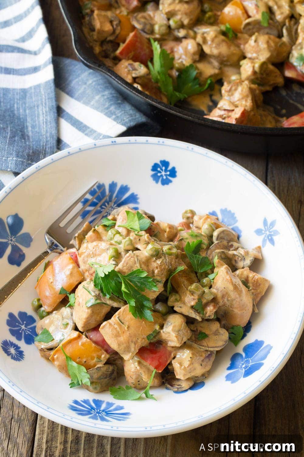 Plated Healthy Chicken a la King with a fork, ready to be enjoyed.