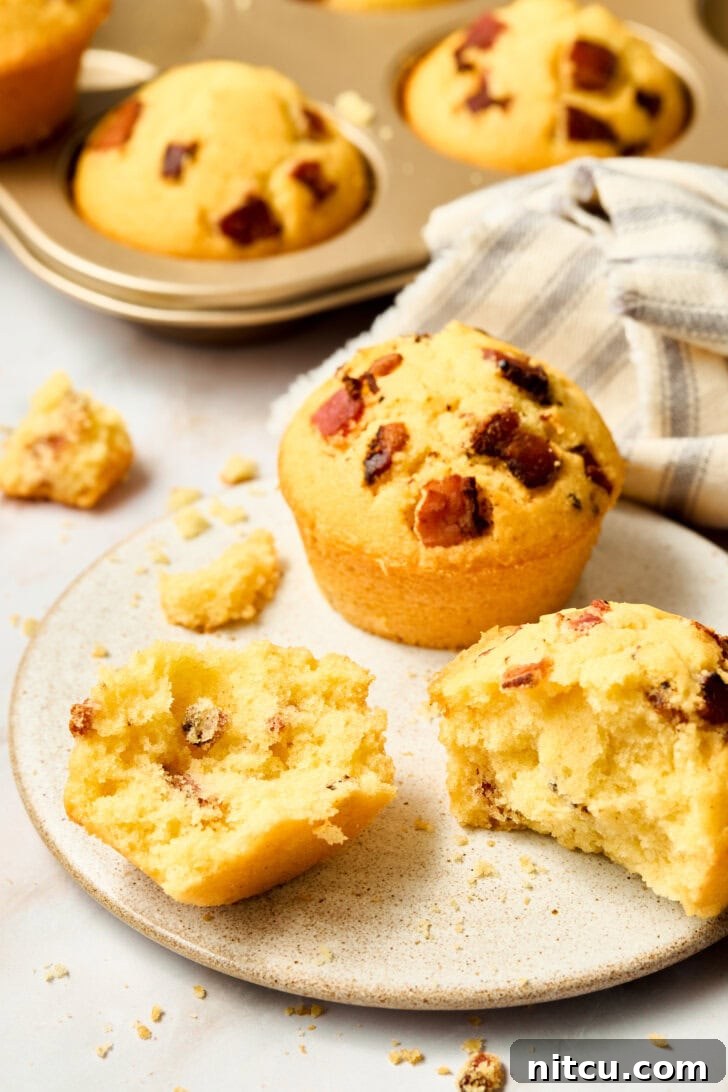 Cornbread muffins cut open on a plate, revealing their moist interior