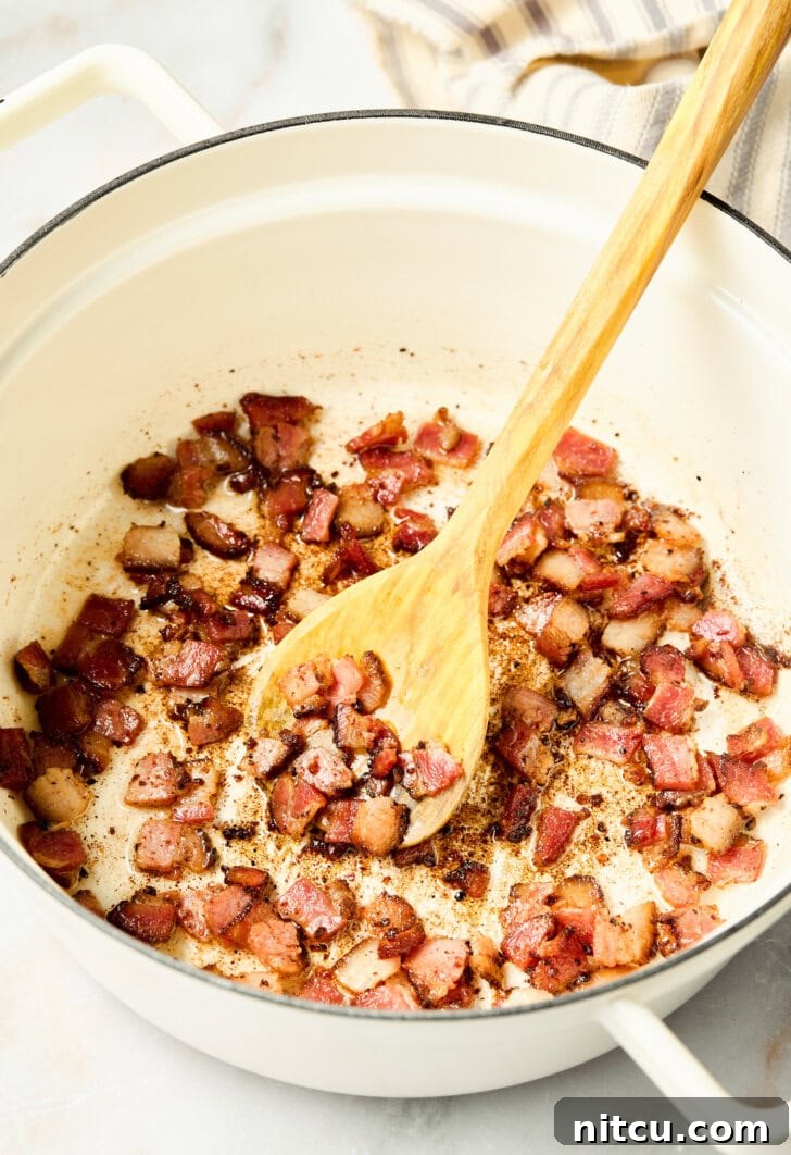 Bacon cooking in a skillet on the stovetop