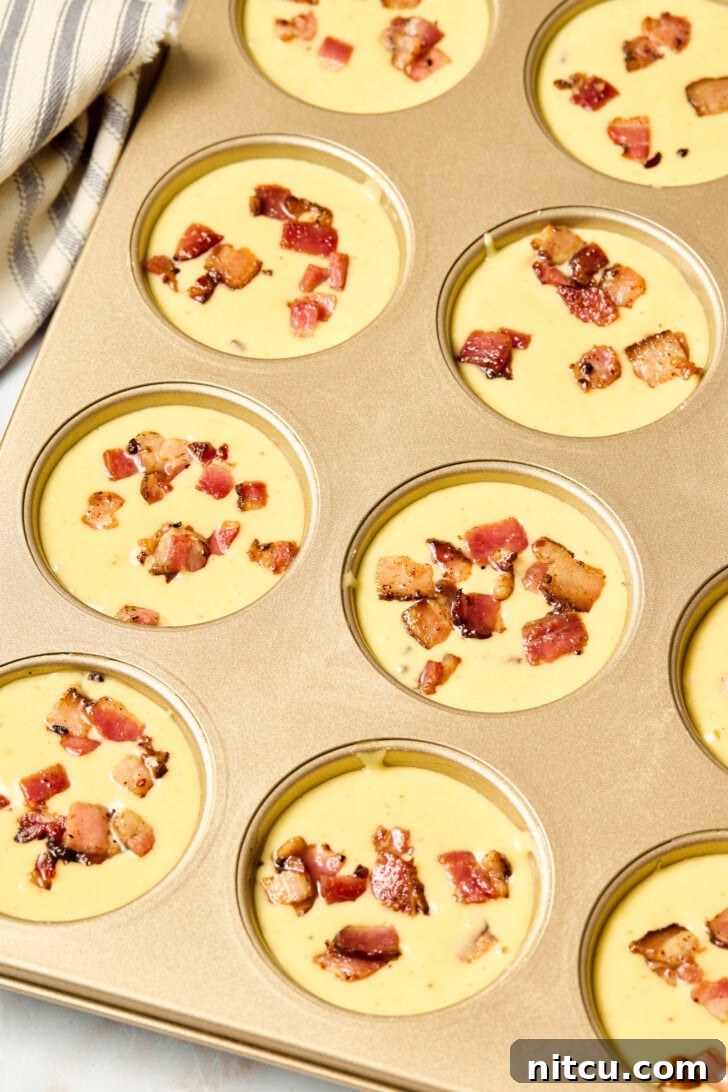 Corn muffin batter poured evenly into muffin pans