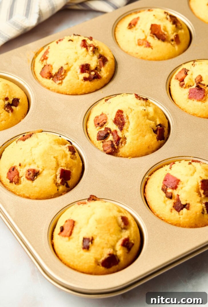Freshly baked golden corn muffins in a muffin pan