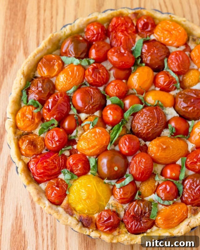 Perfect Fresh Tomato Tart Recipe, an overhead shot of the entire golden-baked pie garnished with fresh basil.