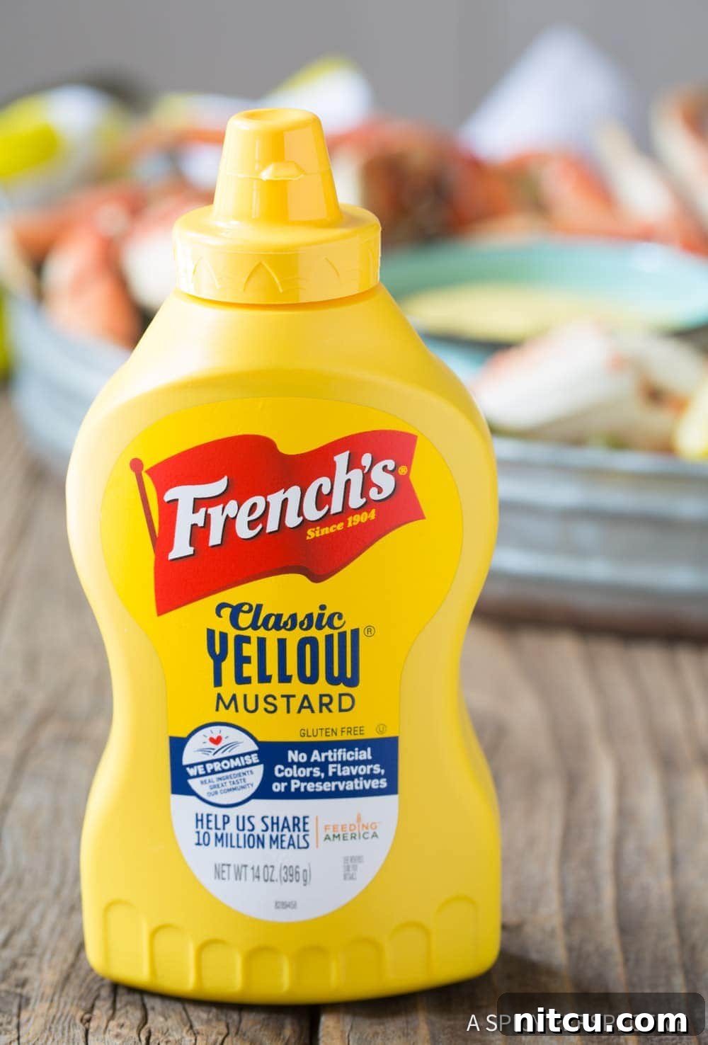 A bottle of French's Classic Yellow Mustard, highlighted as a key ingredient for the seafood sauce.