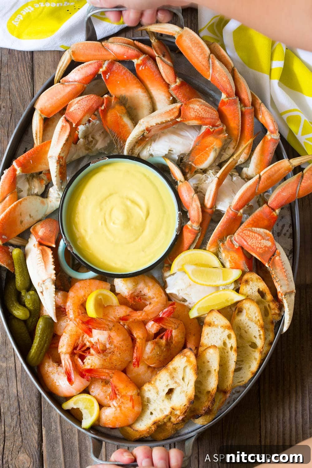 A grand seafood platter, centered by a bowl of the mustard seafood sauce, inviting guests to dip.