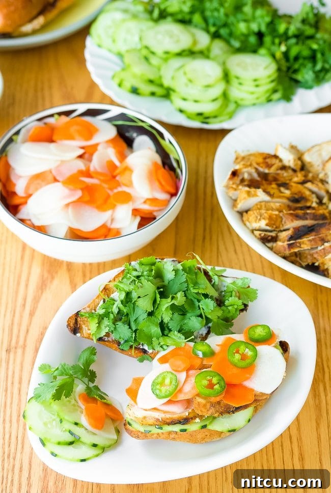Vietnamese Banh Mi recipe - sandwiches on plates piled high with vegetables and herbs