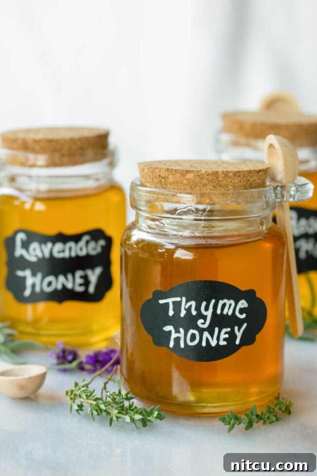 Three small jars of honey labeled 'thyme honey', 'lavender honey', and 'rosemary honey'. 