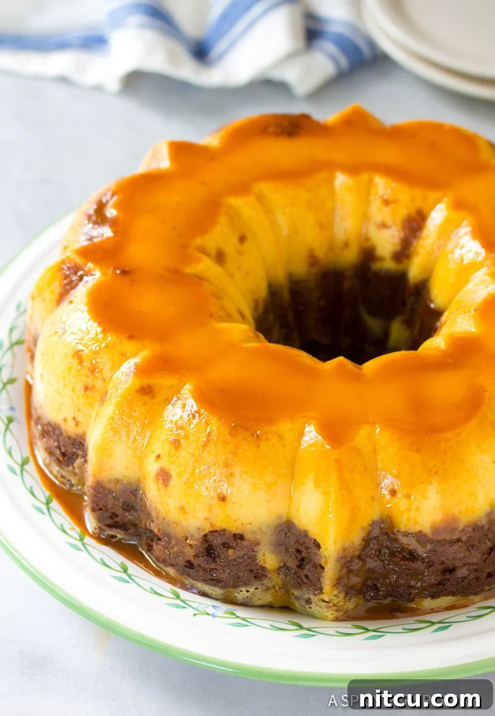 A whole Chocoflan cake sitting on a serving platter, ready to be sliced and served.
