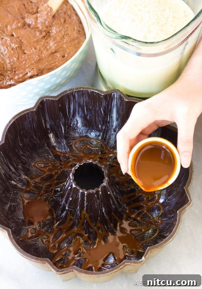 Drizzling caramel sauce into the bottom of a greased bundt pan for Chocoflan.
