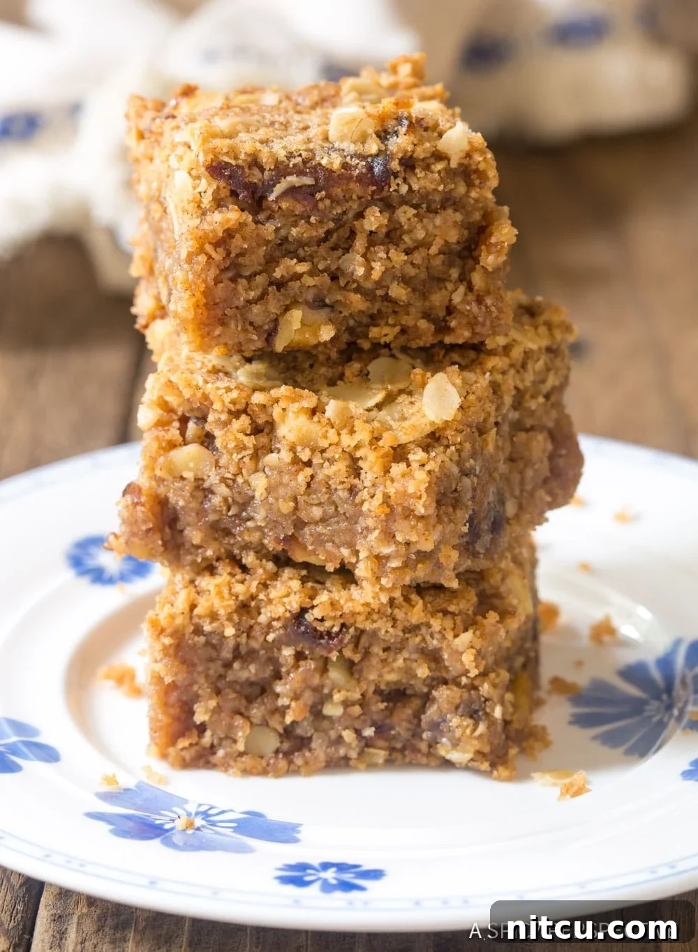 Soft, sweet oat breakfast bars stacked on a rustic wooden surface.