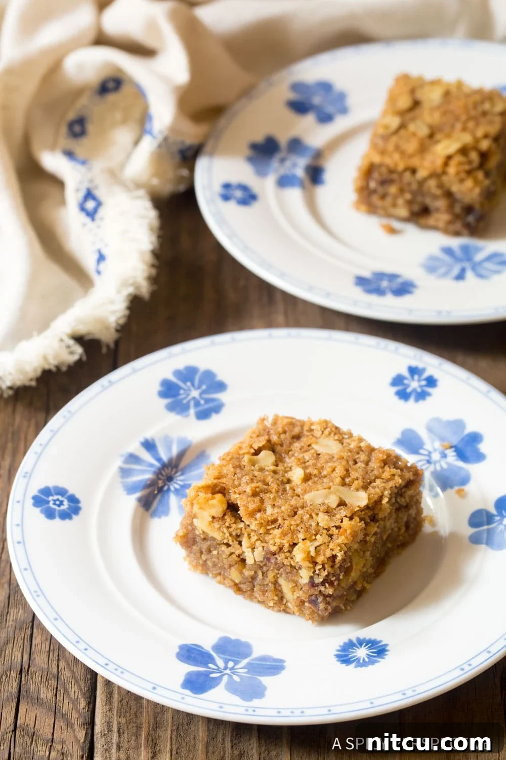 Homemade egg-free oatmeal bars arranged on a charming blue and white patterned plate.