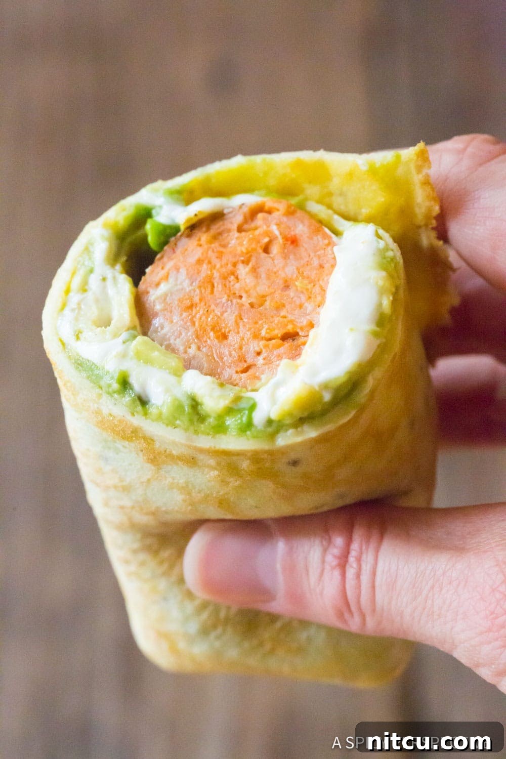 Hand holding an breakfast egg wrap recipe. 