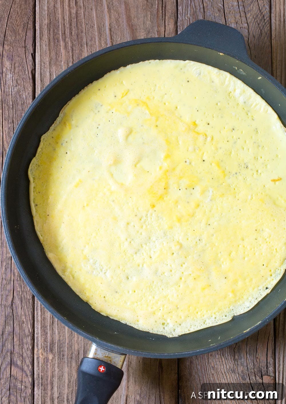 Making an egg tortilla in a skillet. 