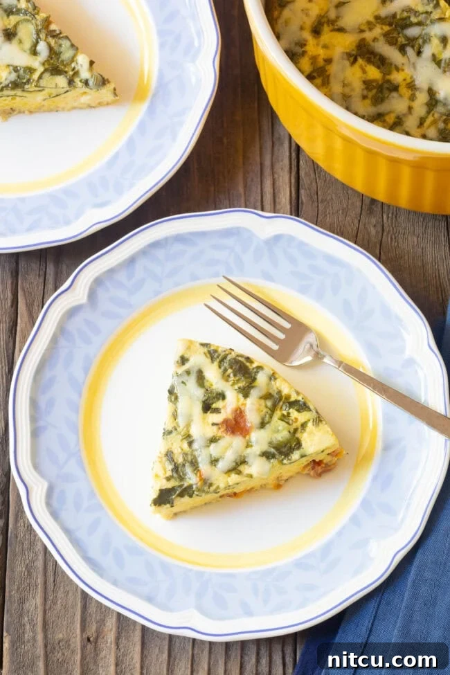A perfectly portioned slice of crustless quiche on a pristine white plate, showcasing its fluffy texture and vibrant fillings.