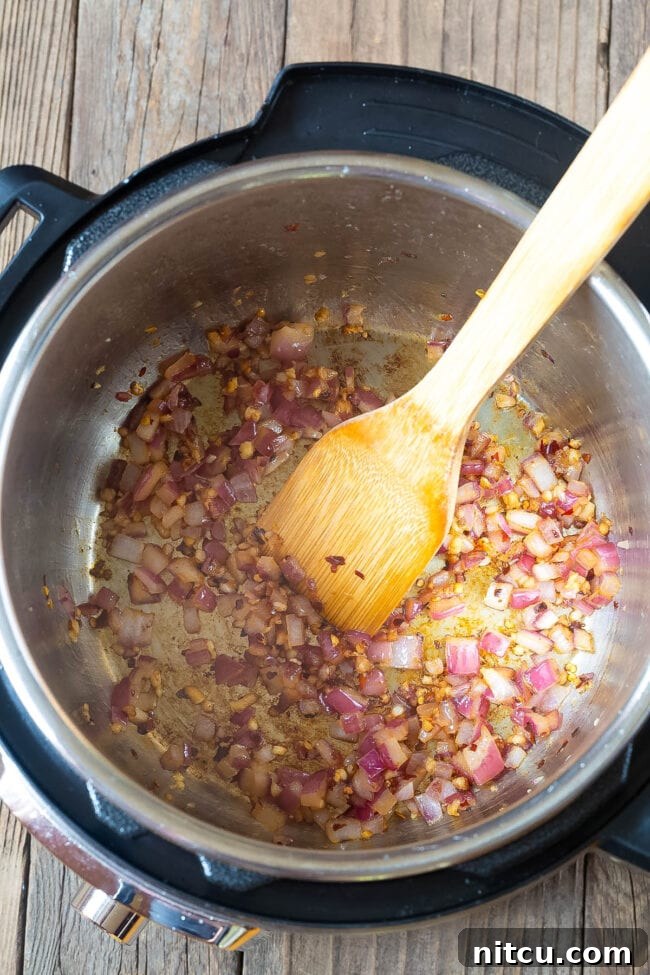 Onions and garlic sauteing in an instant pot. 