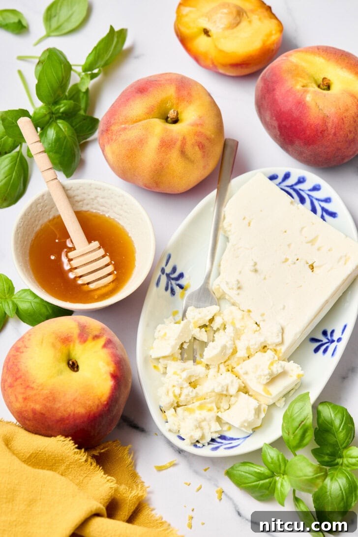 Close-up of fresh peach salad ingredients, including ripe peaches, green basil leaves, and creamy goat cheese, ready for preparation.