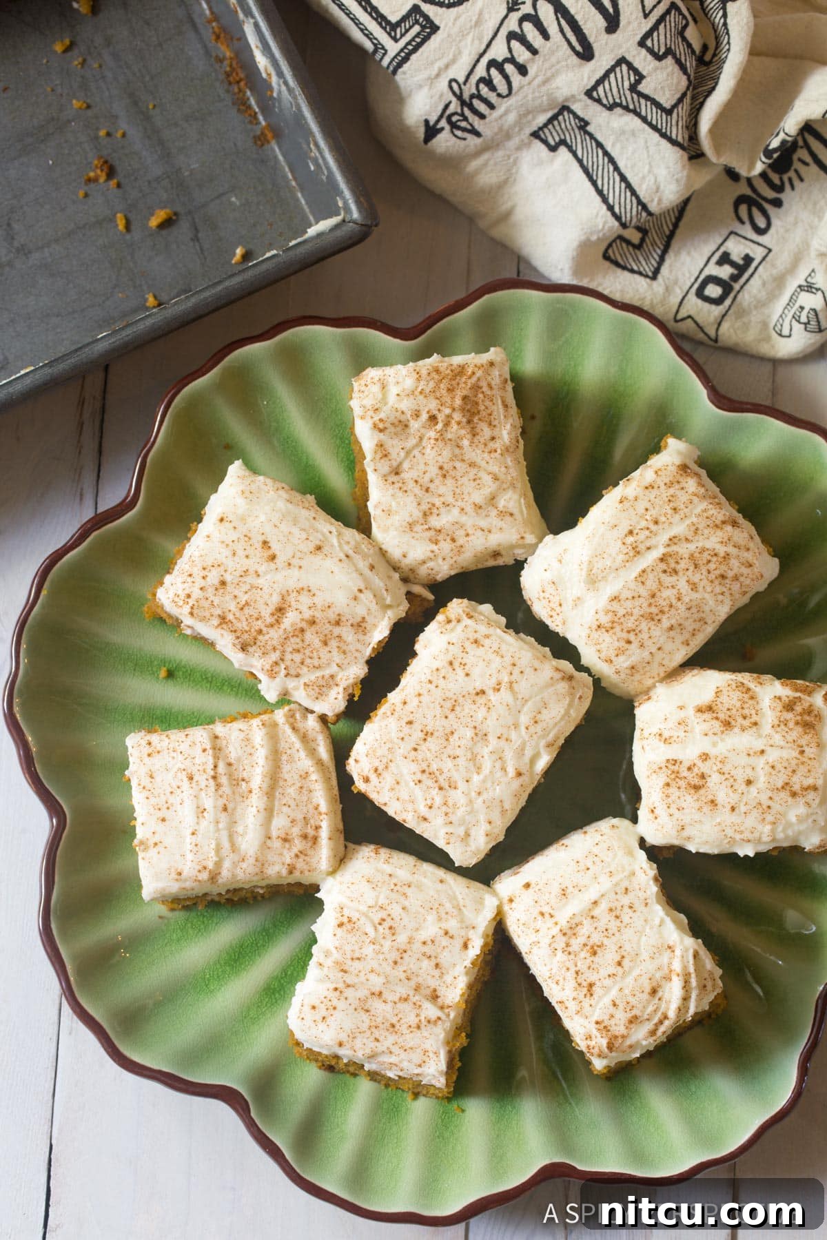Overhead shot of perfectly cut pieces of Pumpkin Texas Sheet Cake with Buttermilk Frosting arranged on a platter, ready to serve.