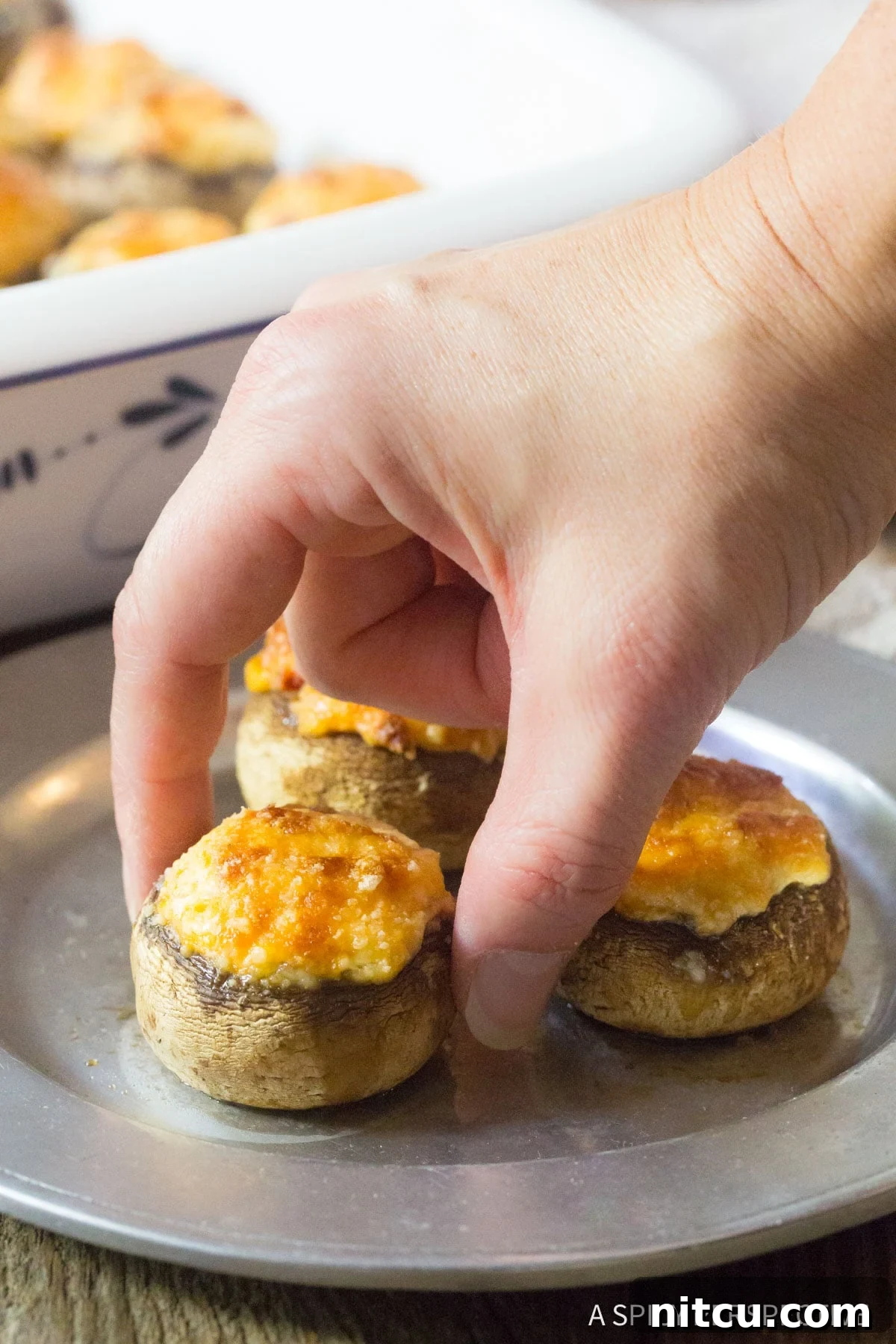 A close-up shot of a mushroom cap generously filled with a creamy, rich blend of cream cheese and parmesan, ready to be enjoyed.