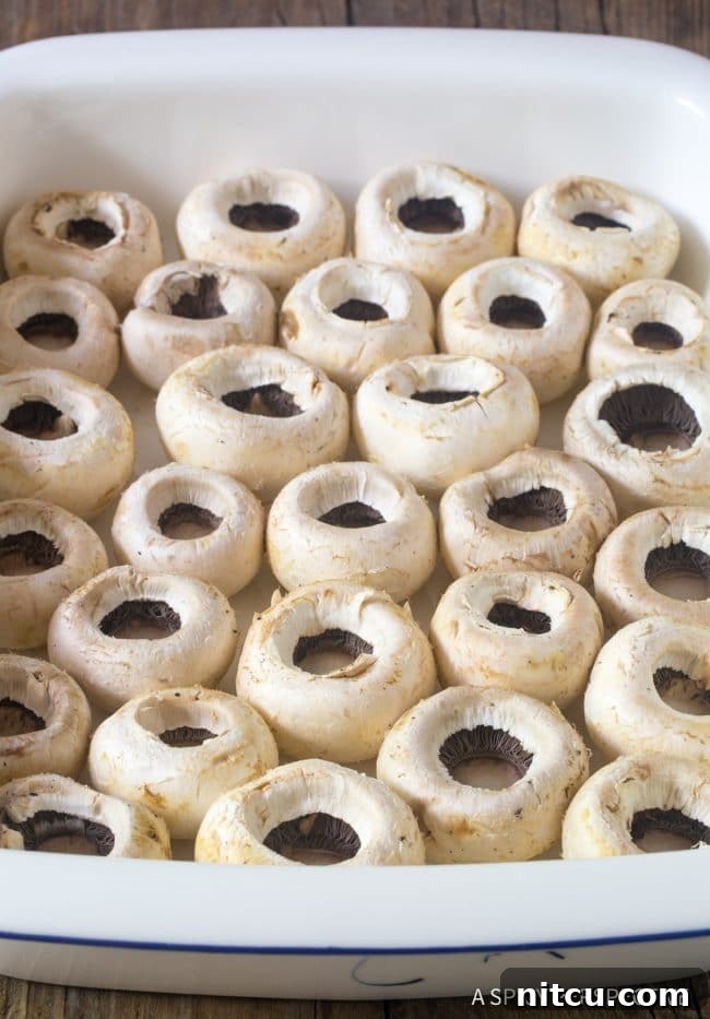 Empty mushroom caps carefully arranged in a baking dish, prepped and ready for the delicious filling.