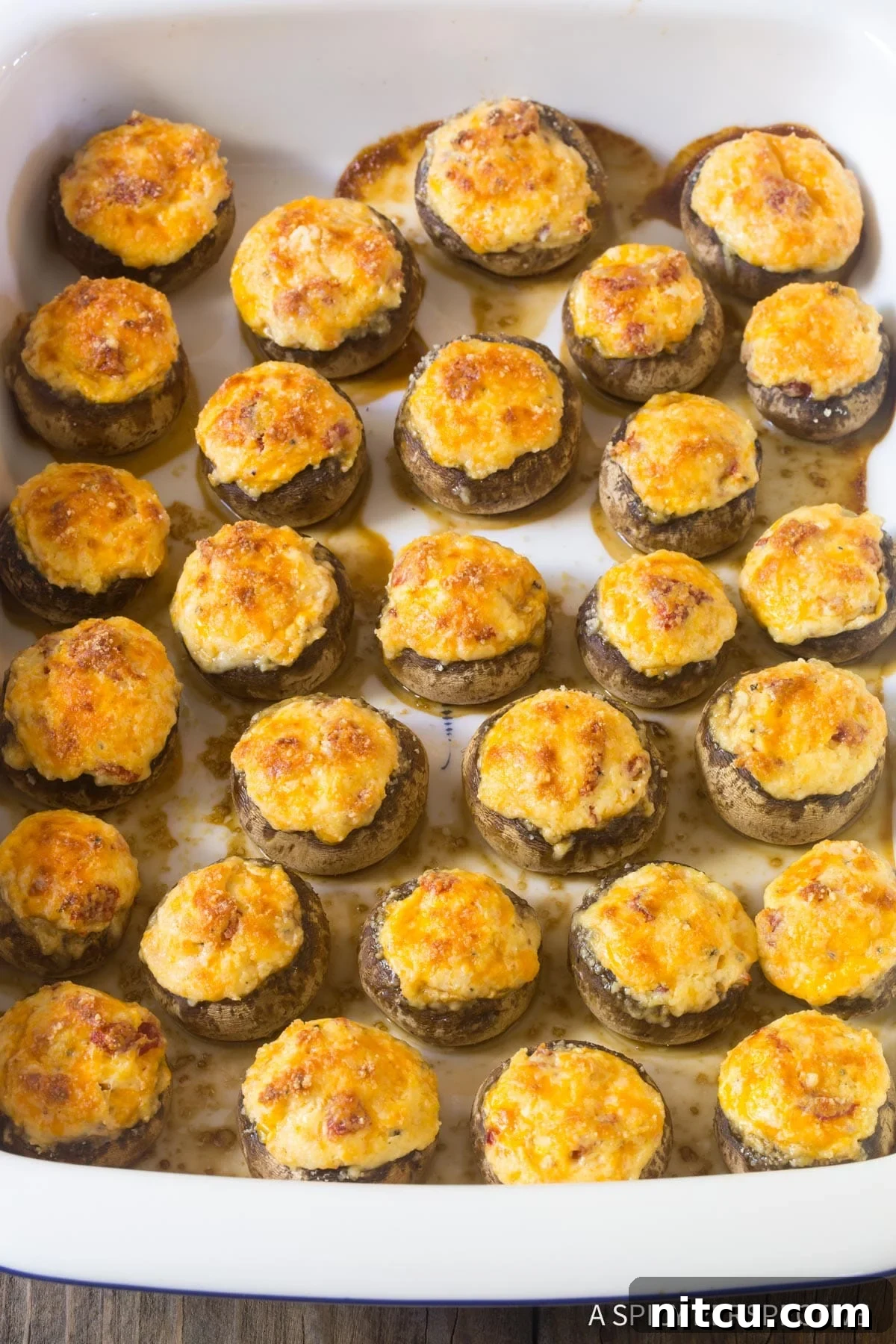 A casserole dish filled with melty mushroom caps, showcasing the rich, three-cheese filling, ready to be enjoyed.