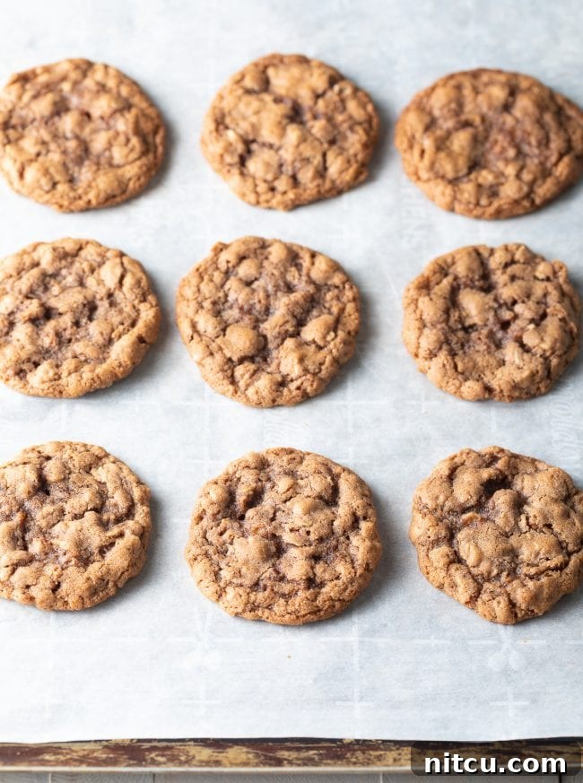 Freshly baked, soft oatmeal cookies cooling on a wire rack.