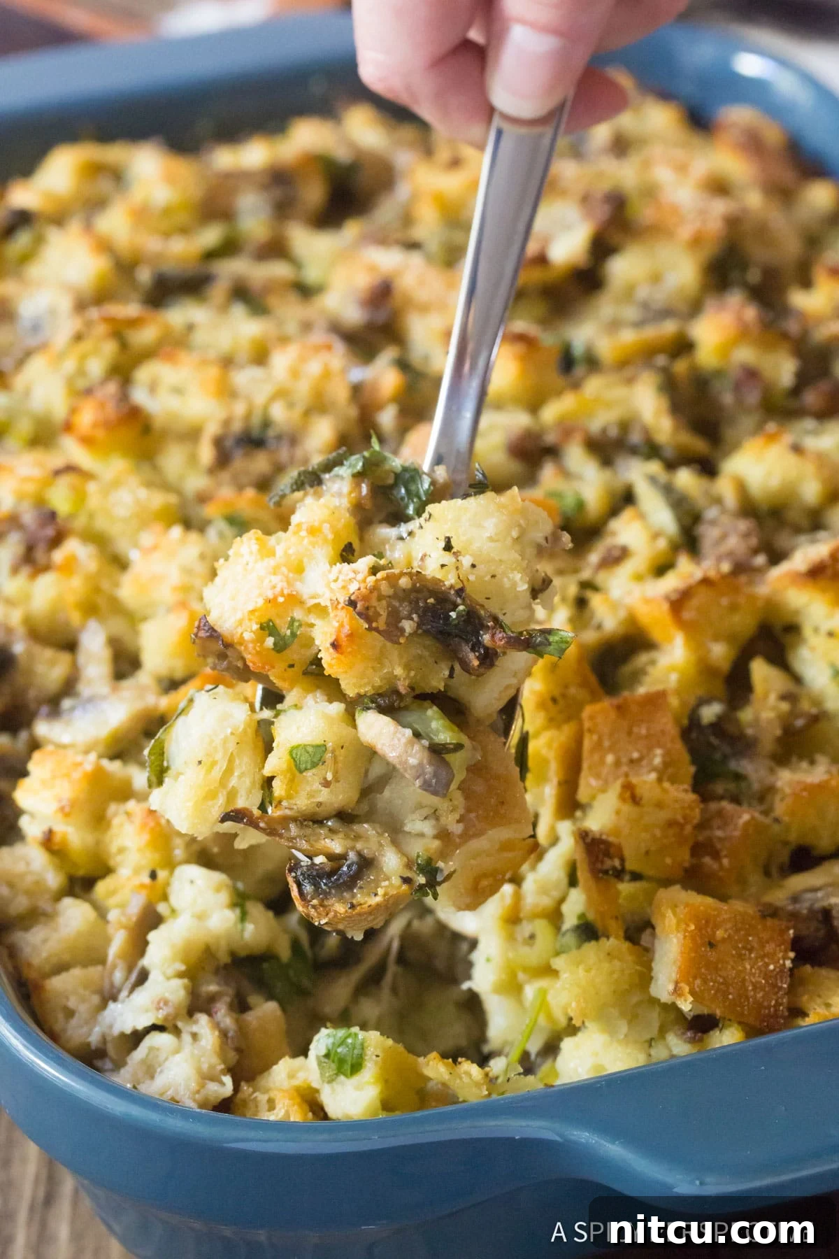 Best Sausage Mushroom Stuffing Recipe, spooned up with serving spoon.