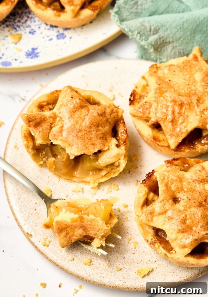 Mini Apple Pie cut open with sweet brandy apples exposed, showing the rich filling and flaky crust.