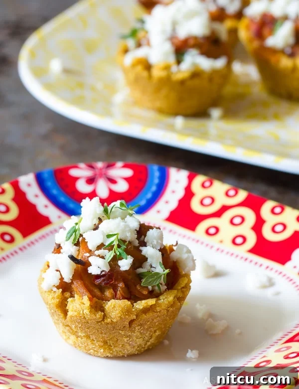 A plate of freshly baked Mini Tamales, generously topped with crumbled cheese and ready to serve.