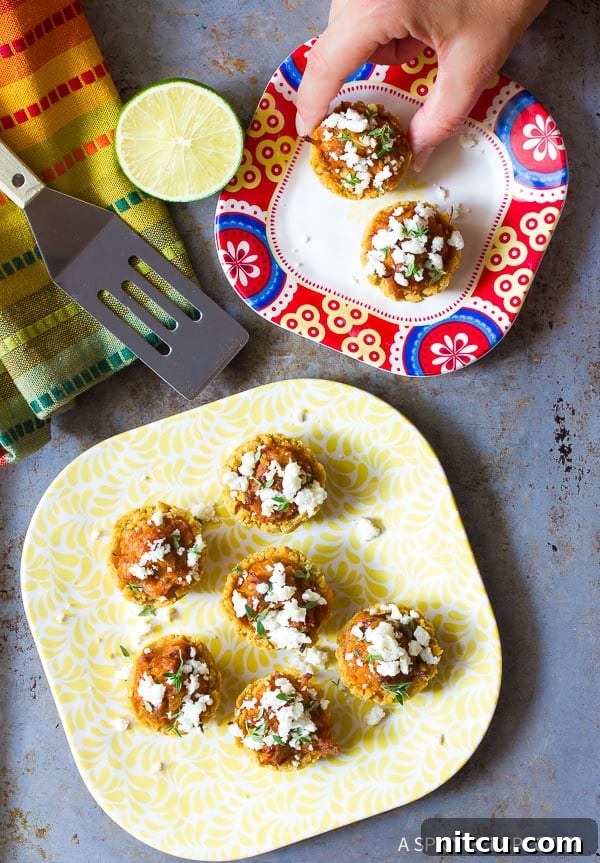 A close-up view of freshly baked Mini Tamales on a plate, garnished with crumbled queso fresco.