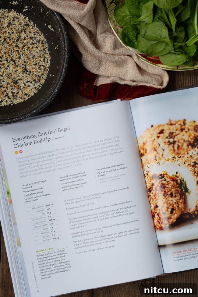 An open page of SkinnyTaste's cookbook, prominently displaying the mouth-watering 'Everything (but the) Bagel chicken roll-ups' recipe, inviting readers to try it.