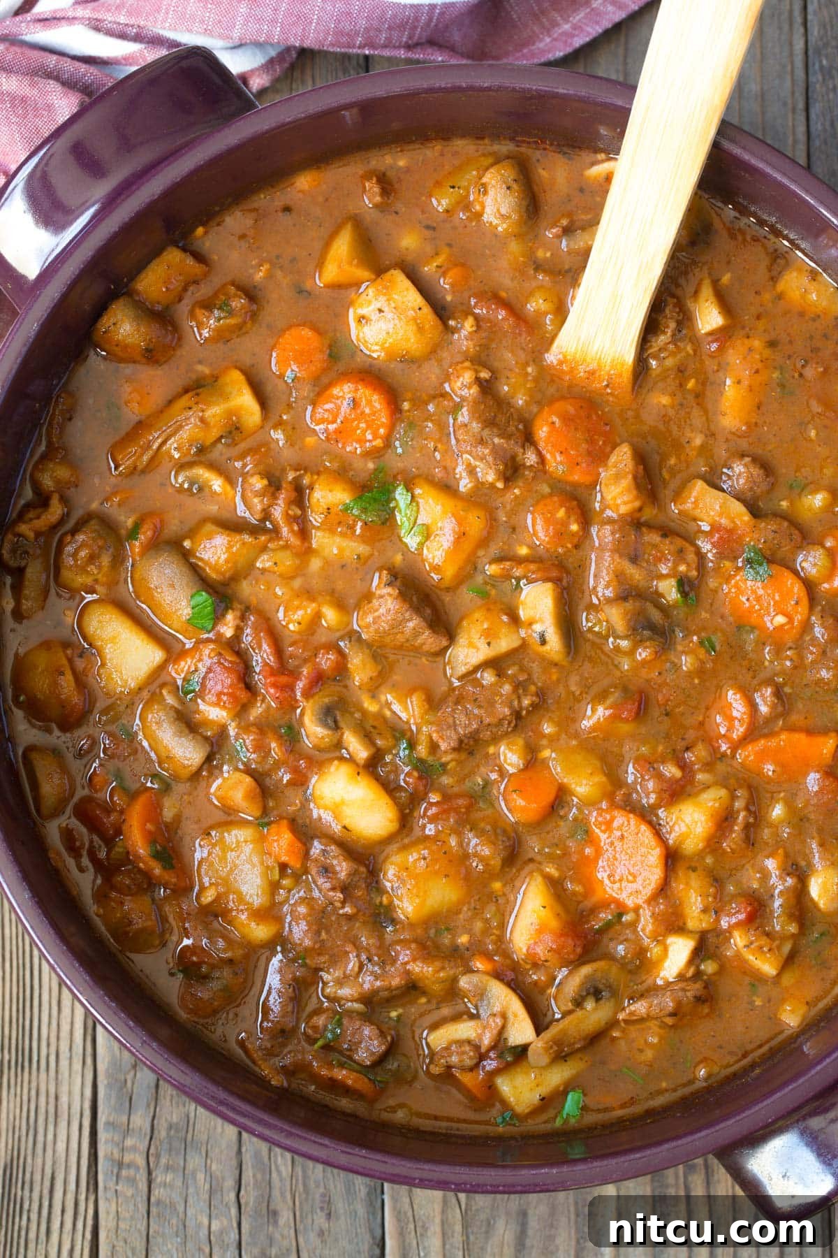 Hearty beef stew simmering in a rustic Dutch oven, garnished with fresh herbs, ready to be served on a cozy evening. Best Beef Stew Recipe.