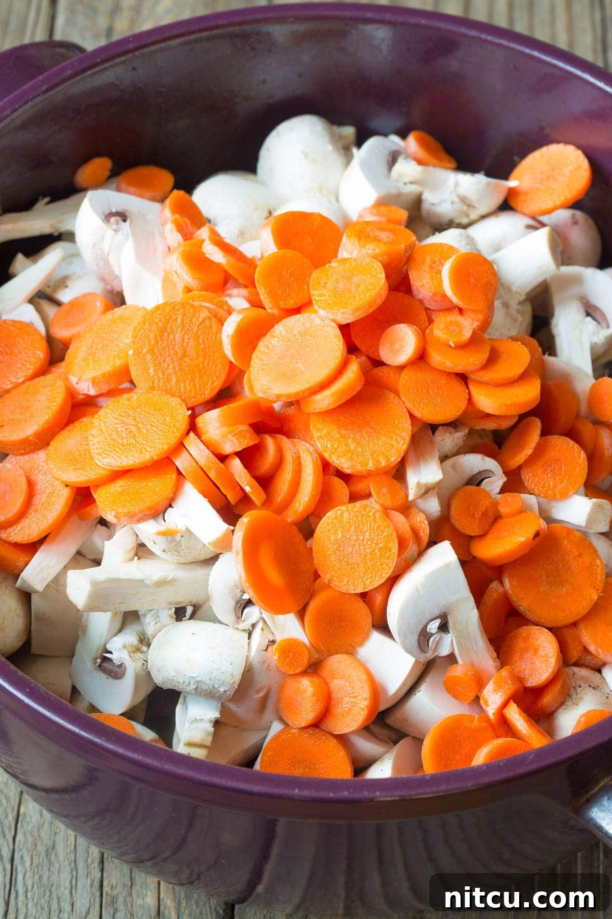 Chopped vegetables, beef, and broth simmering together in a pot.