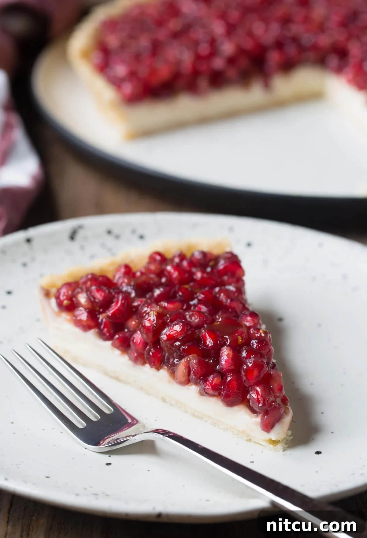 Easy 6-Ingredient Pomegranate Tart Recipe - cut on plate with fork
