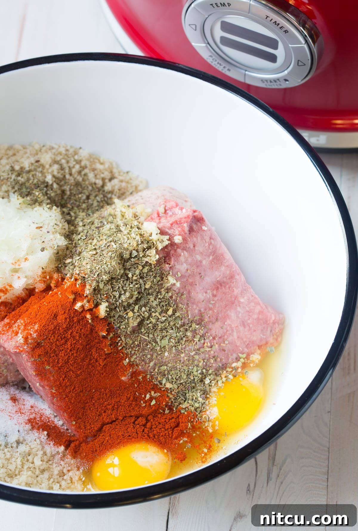 Ingredients for homemade cocktail meatballs: ground meat, spices, eggs, and breadcrumbs